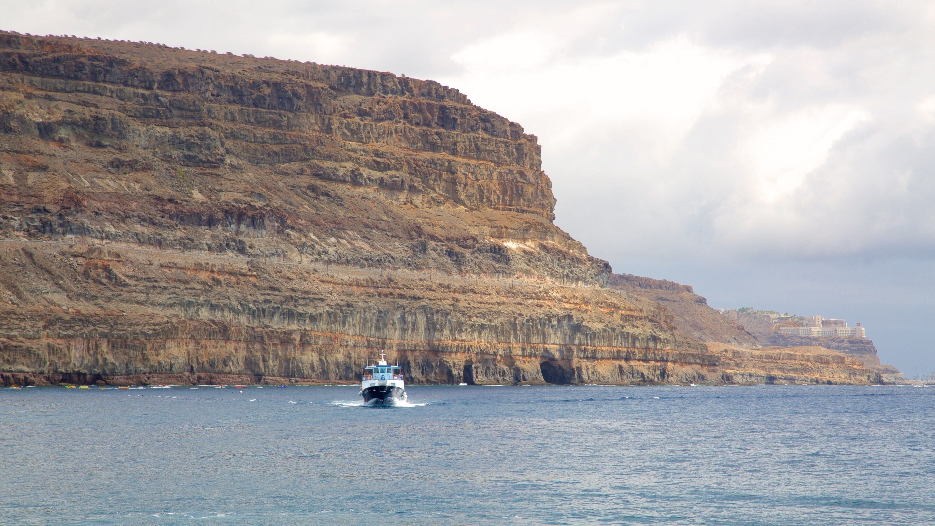 Mogan which includes general coastal views, boating and rocky coastline