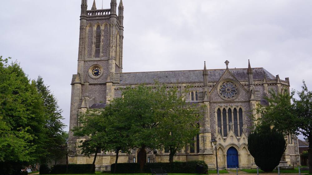 A historic church with a tall clock tower and a large circular window.