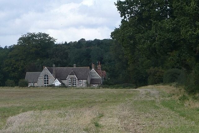 Between the Chutes From a footpath between Lower Chute and Upper Chute. The building, which looks like an old school house, is on Malthouse Lane between Upper Chute and Chute Standen.