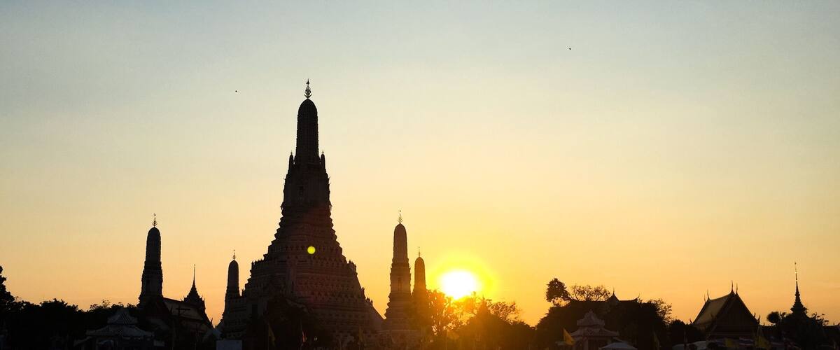 Landmark of Bangkok, the temple of dawn at dusk from the Chaophraya river.