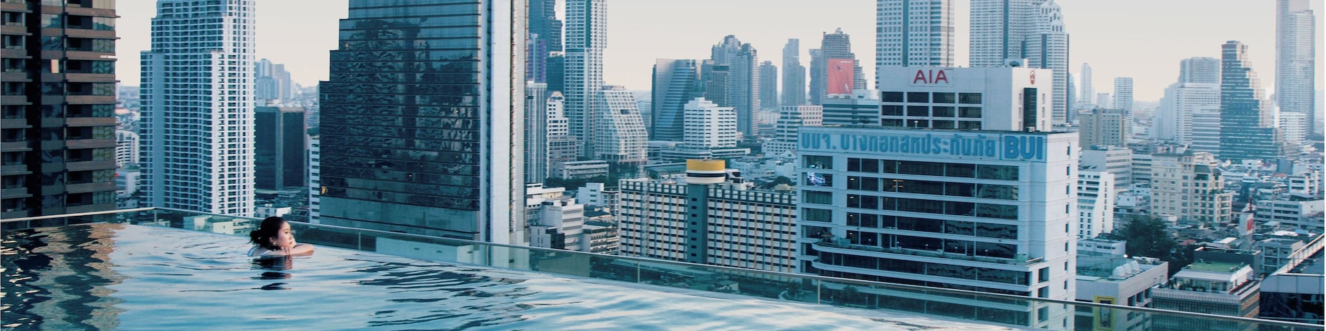 Vista de la ciudad con un edificio grande que muestra la etiqueta 'pulmón' y otro con 'AIA' en una piscina en la azotea.