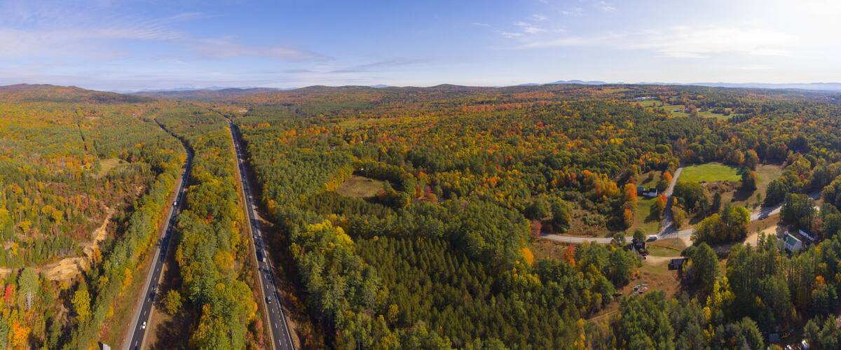 Interstate Highway 93 at Exit 22 with NH Route 127 in White Mountain National Forest panorama aerial view with fall foliage, Town of Sanbornton, New Hampshire NH, USA.