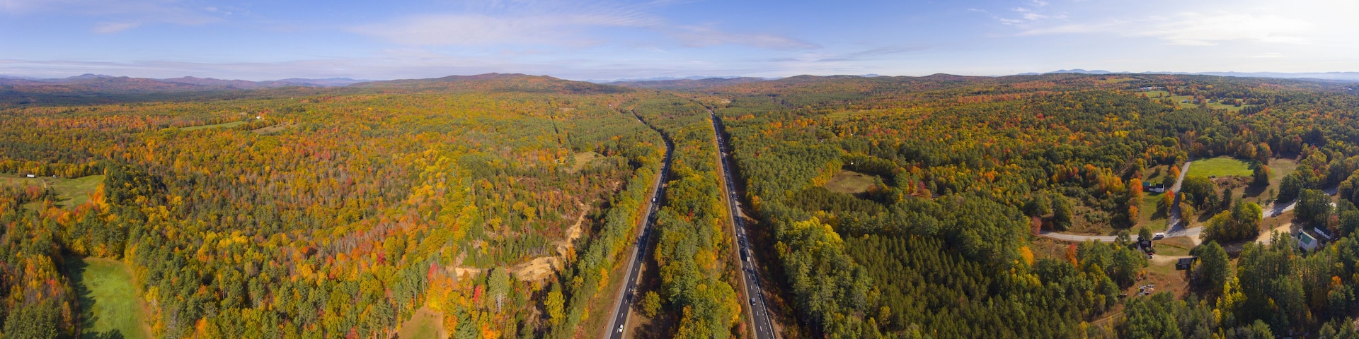 A vast forest with a road cutting through it.