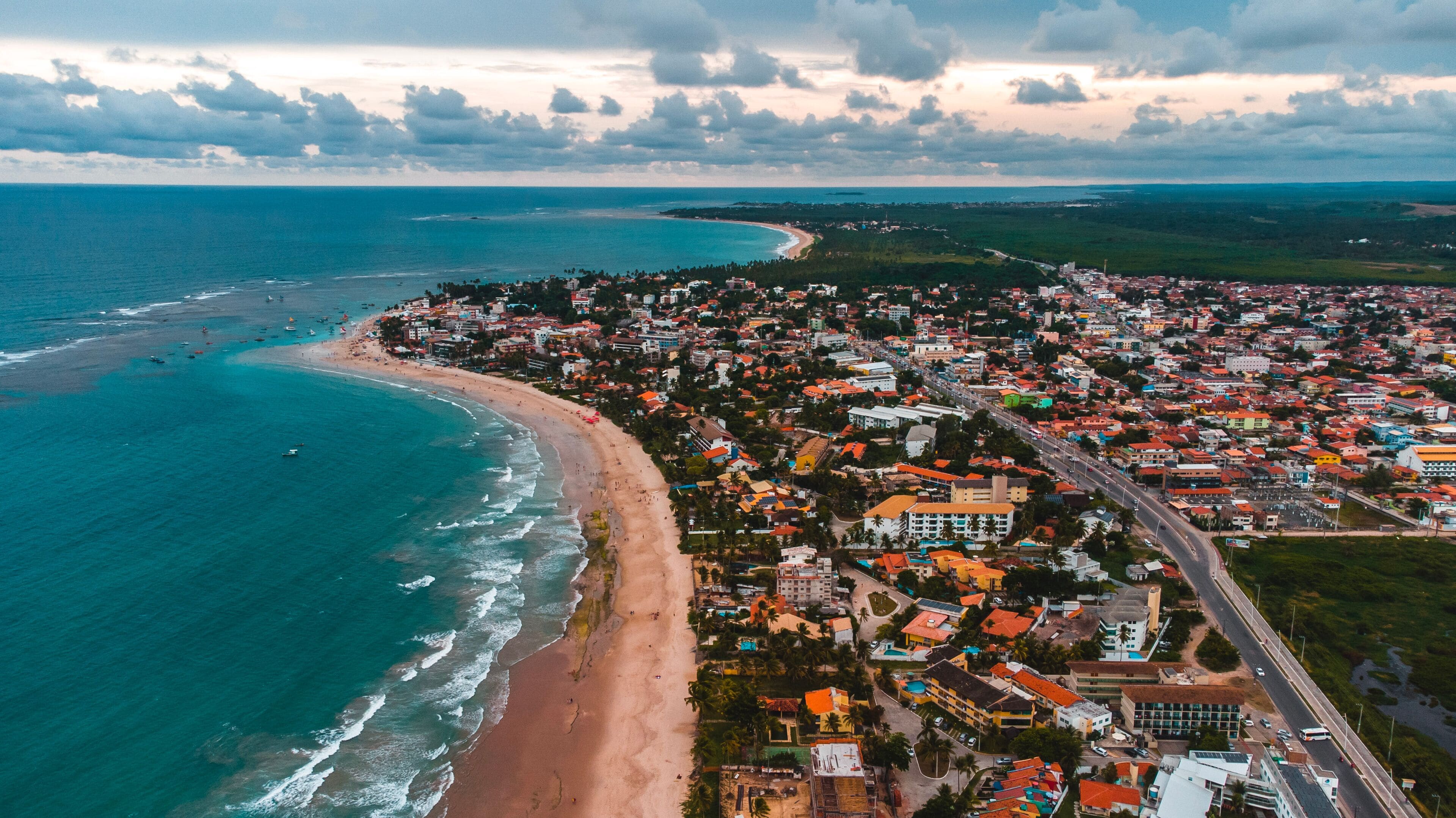 Un pueblo costero con playa, océano y una zona urbana densa.