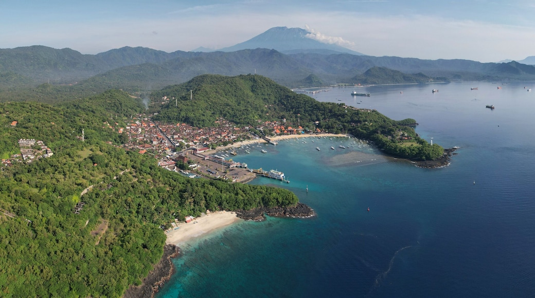 Panoramic drone view of Bias Tugel Beach, Padangbai bay and Mount Agung on sunny day. Manggis, Bali, Indonesia.