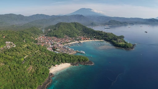 Panoramic drone view of Bias Tugel Beach, Padangbai bay and Mount Agung on sunny day. Manggis, Bali, Indonesia.