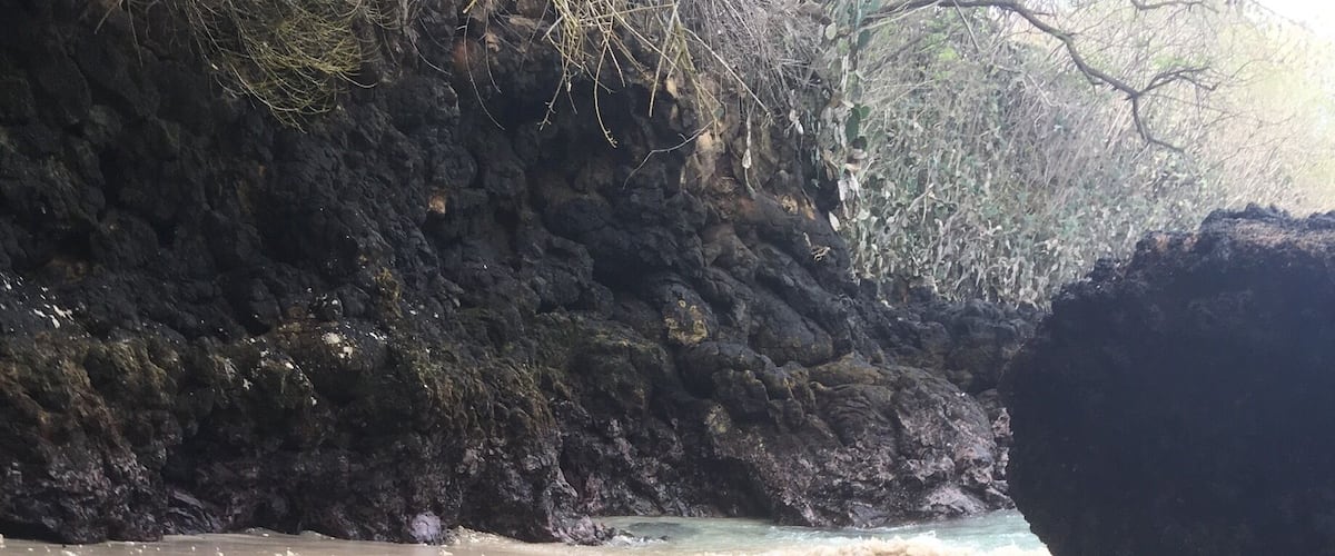 A little beach with a mix of black and white sand 
Be careful because there is a strong current