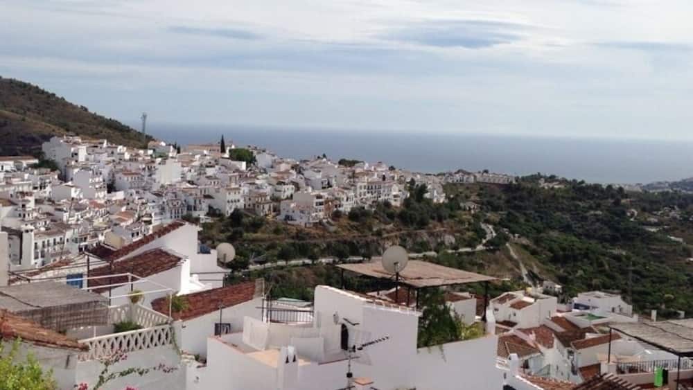Une ville côtière aux bâtiments blancs, aux toits en terrasses et qui offre une vue sur la mer.