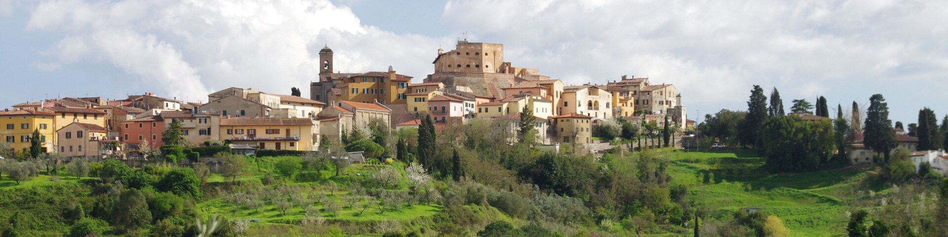 A hillside town with historic buildings and lush greenery.