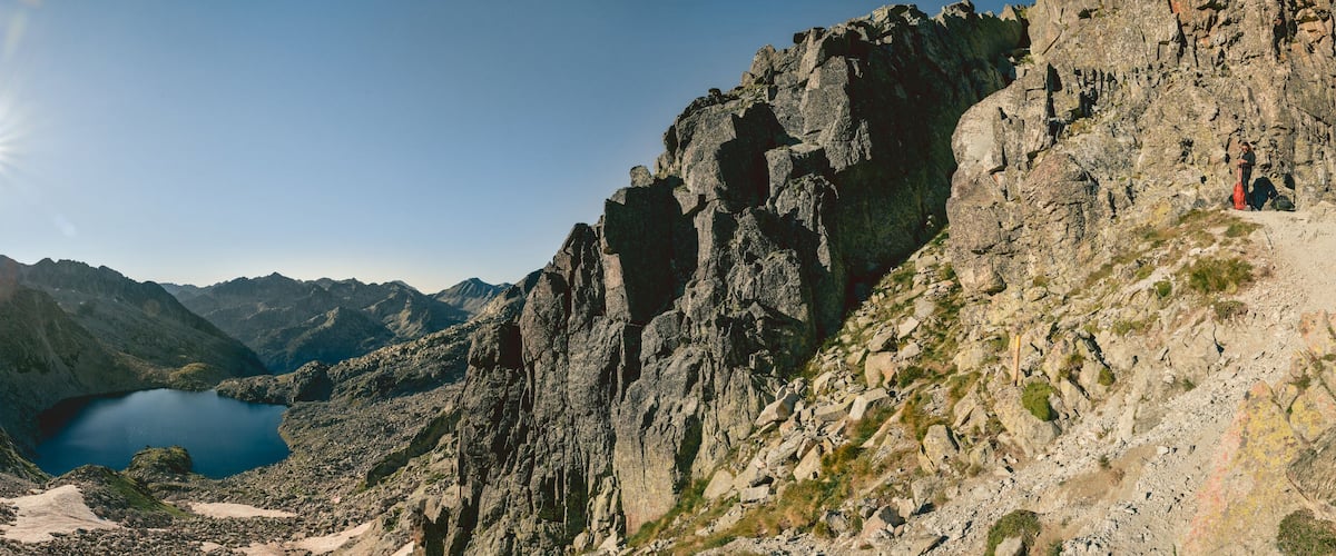 A mountainous landscape with a lake surrounded by steep cliffs.