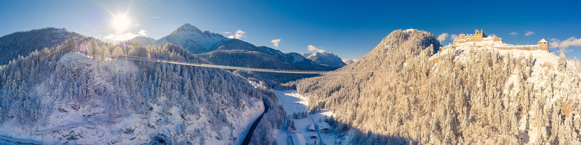 A snow-covered mountain landscape with a bridge and a castle.