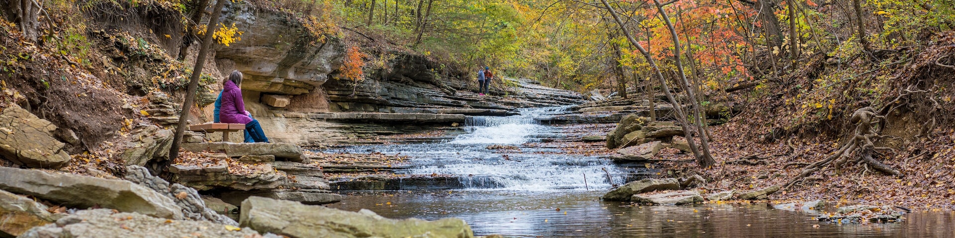 Tourists sitting on bench at Tanyard Creek Nature Trail Bella Vista, Northwest Arkansas
