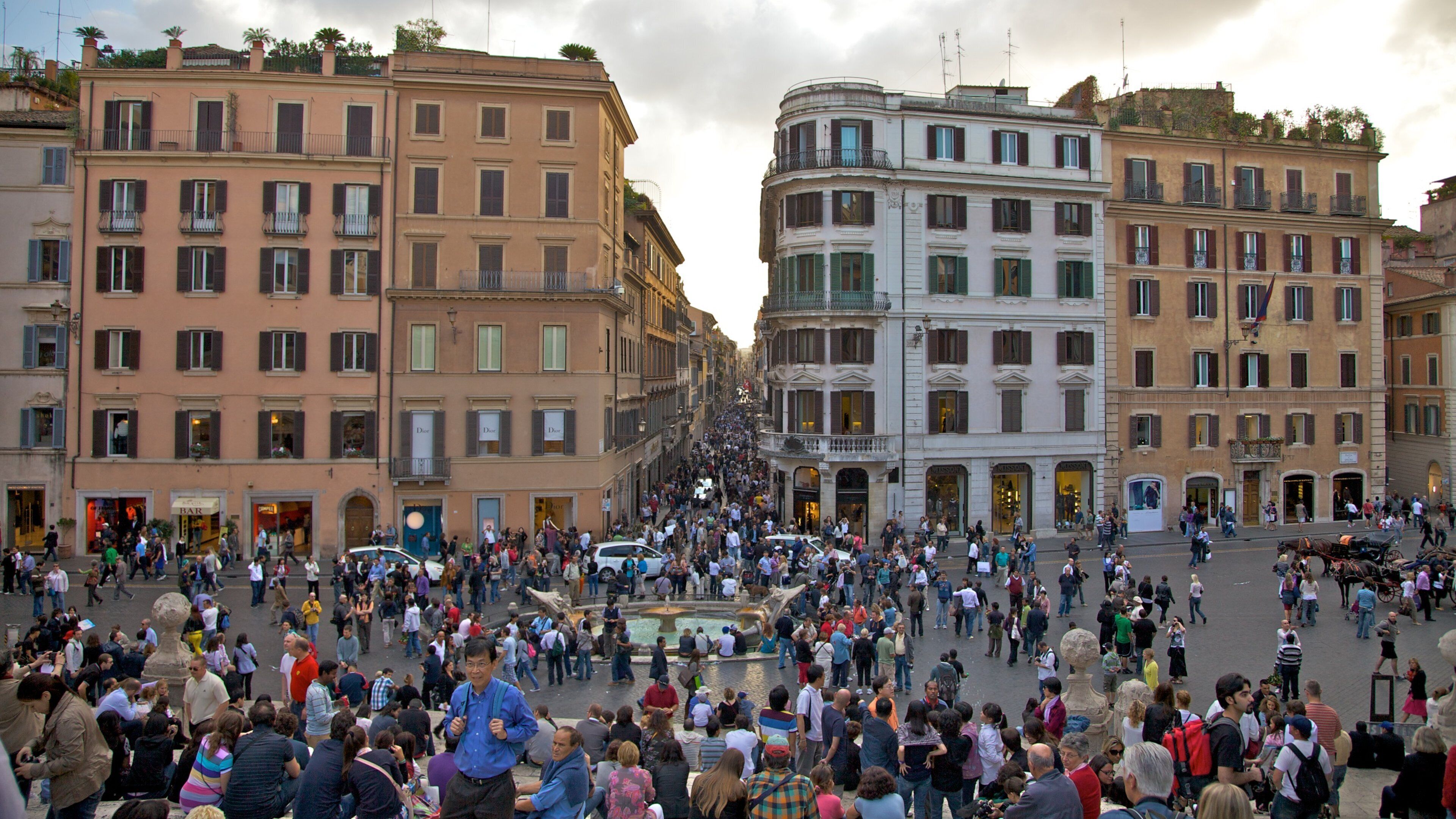 Crowds gather on the Spanish Steps in Rome, highlighting vibrant city life and historic architecture in the heart of Italy