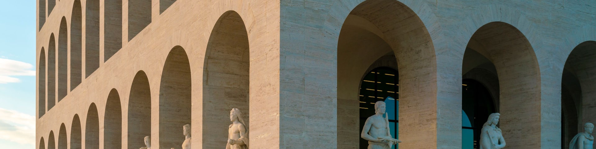 A building with multiple arched doorways, each with a statue.