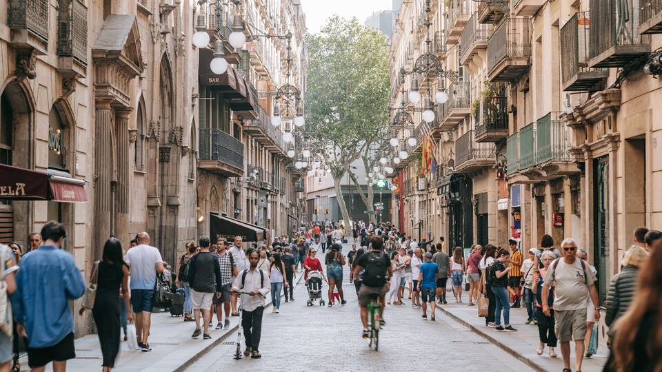 Una strada affollata fiancheggiata da edifici storici e lampioni decorativi.