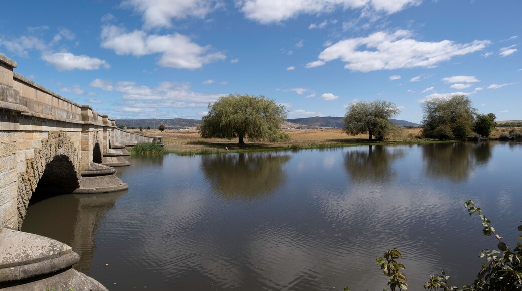 Historic sandstone convict bridge over the Macquarie river in Ross, Tasmania, Australia with beautiful sunny landscape. Widescreen image