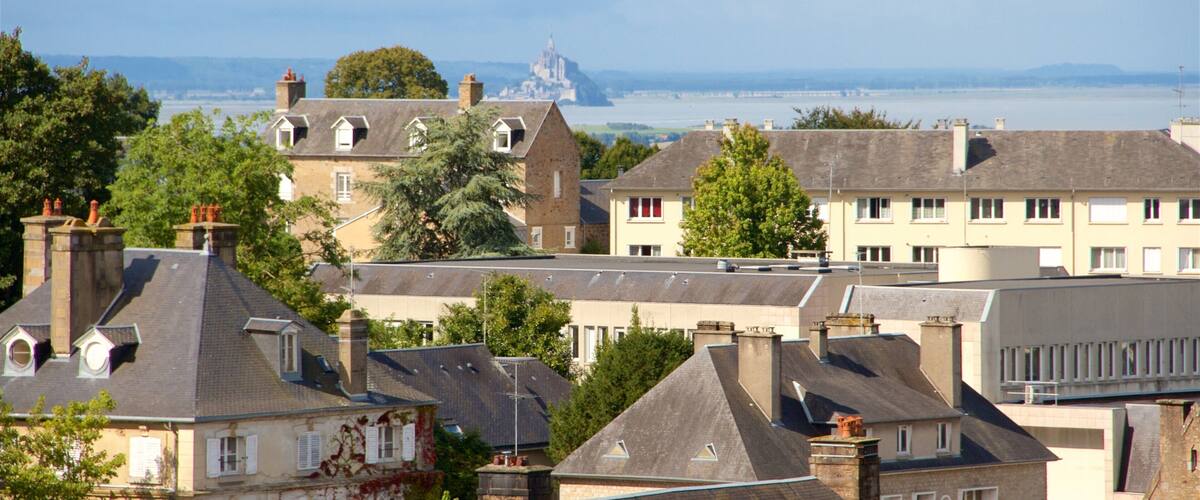 A coastal town with historic buildings, a prominent church, and a distant castle.