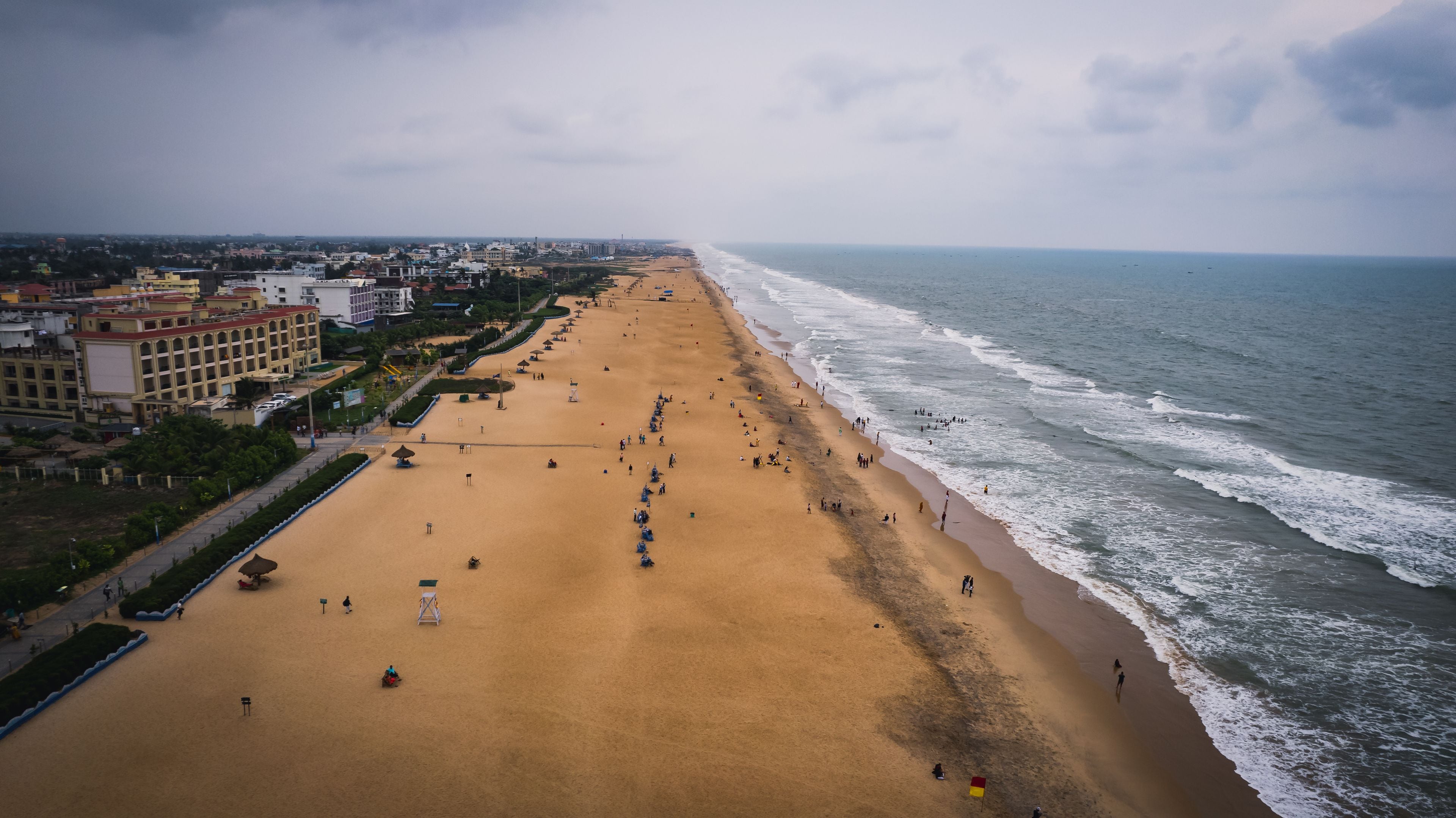 Une vaste plage de sable fin, avec une vue sur la ville en arrière-plan.
