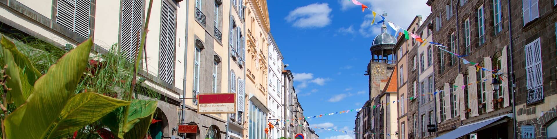 Riom which includes a city and outdoor eating as well as a small group of people