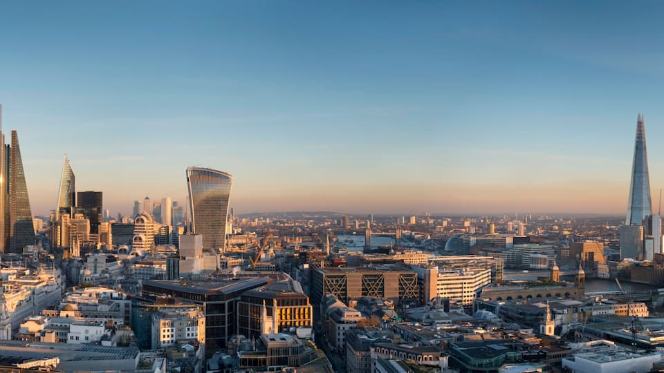 A cityscape with prominent skyscrapers, including a distinctive curved building and a tall, slender tower.