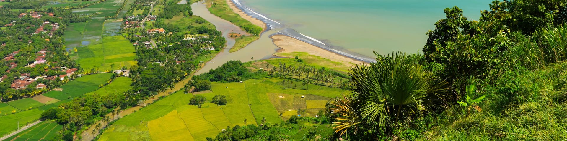 View from above, expanse of rice fields, beach, and rural atmosphere in the Ciletuh Geopark area, Sukabumi, West Java, Indonesia. The Ciletuh area has been designated as a UNESCO Global Geopark.