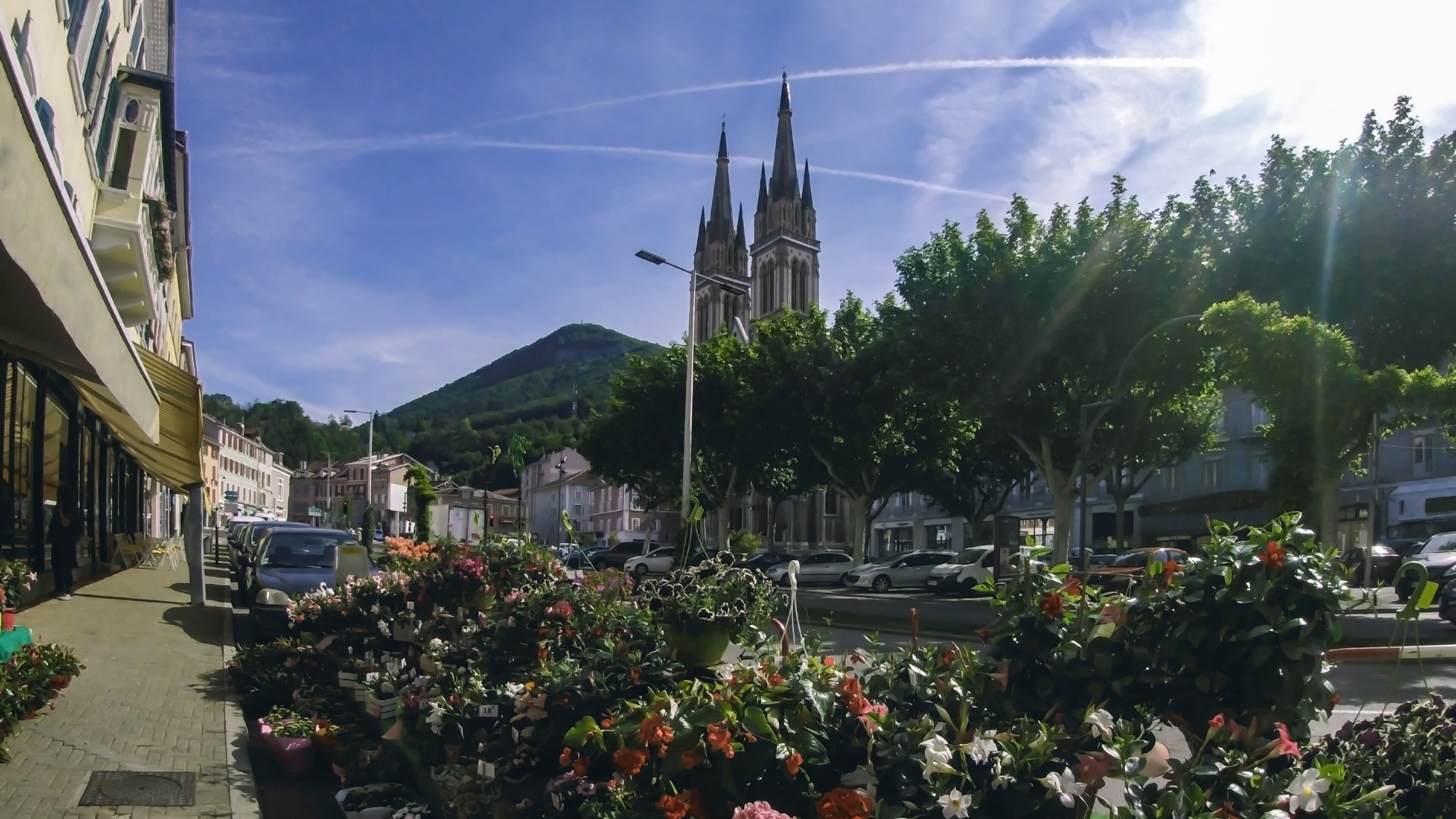 City center with a flower shop in the foreground and the Cathedral in the background. Voiron France