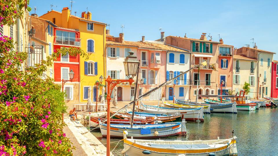 A waterfront with colorful buildings and boats docked along the shore.