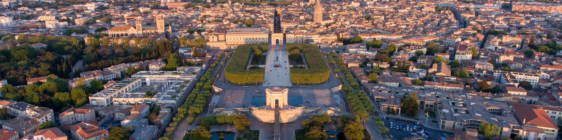 Vista aérea de una ciudad con una plaza central destacada, rodeada de edificios históricos y un gran monumento.