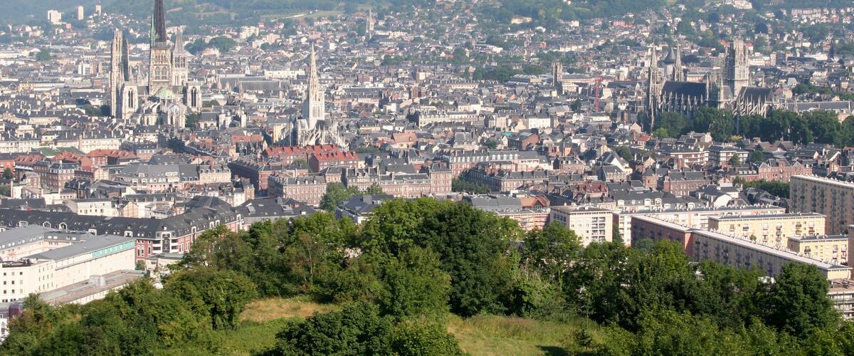 A cityscape with historic buildings and a prominent church spire.