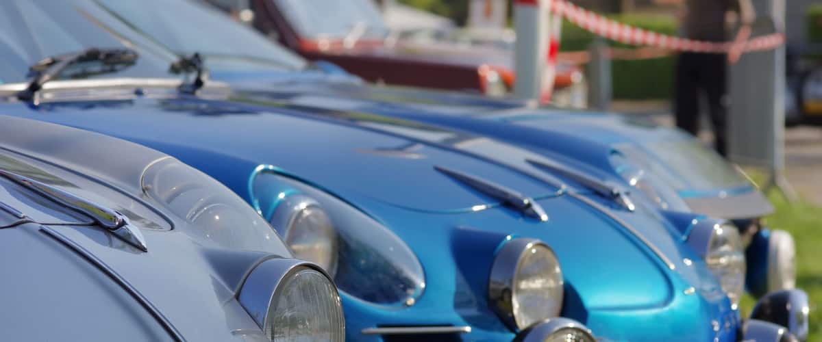 A close-up of a blue vintage car with chrome details and a classic design.