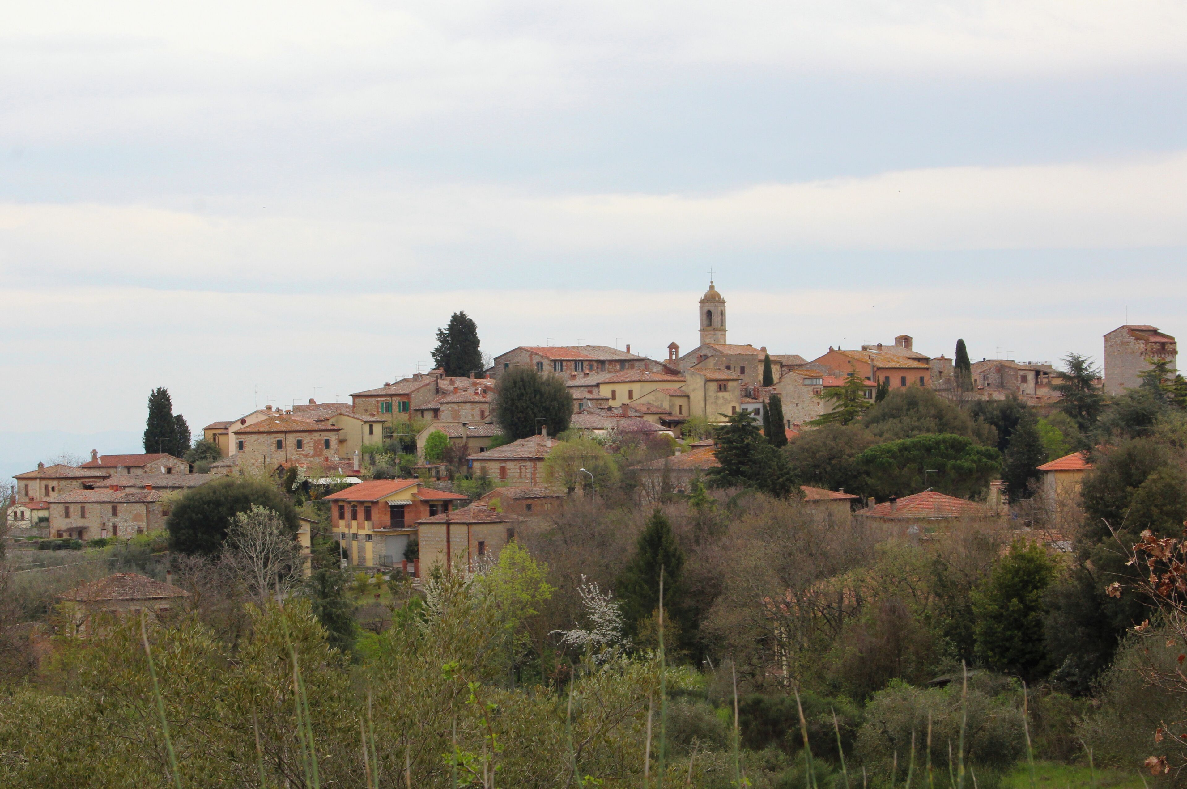 A hillside village with historic buildings and a prominent church tower.