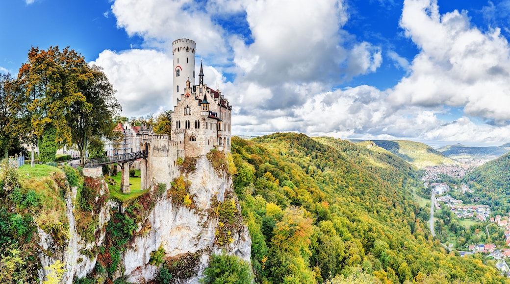 Germany, Lichtenstein Castle in Baden-Wurttemberg land in Swabian Alps. Seasonal panorama of Lichtenstein Castle on a cliff circled by colorful trees, German countryside . European famous landmark.