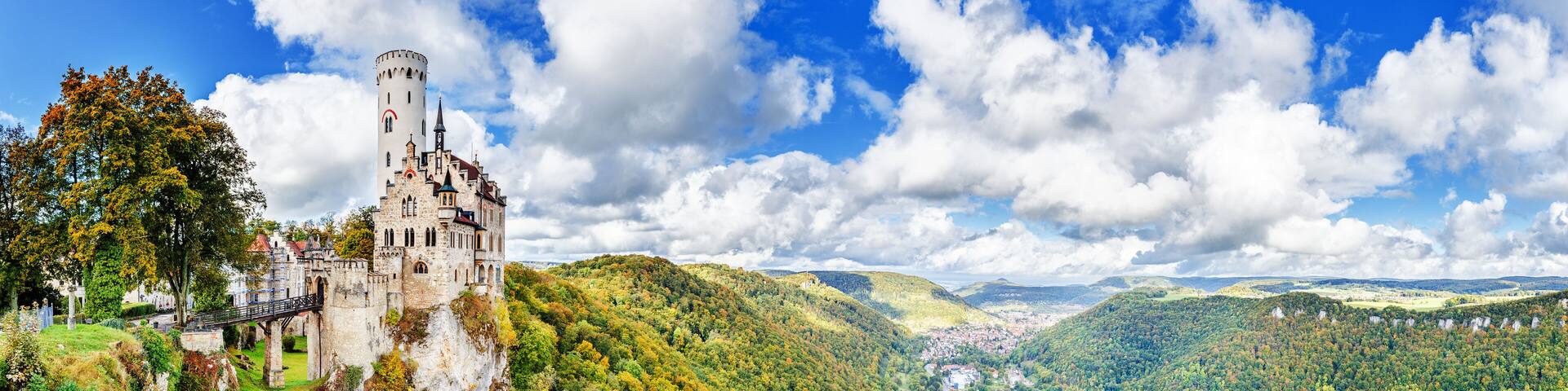 Germany, Lichtenstein Castle in Baden-Wurttemberg land in Swabian Alps. Seasonal panorama of Lichtenstein Castle on a cliff circled by colorful trees, German countryside . European famous landmark.