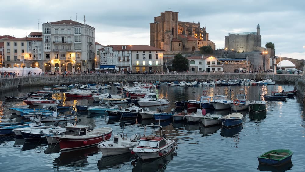 Harbour of Castro Urdiales in Cantabria, Spain. Church of Santa MarĂa de la AsunciĂłn and lighthouse in Castle of Santa Ana at the background.