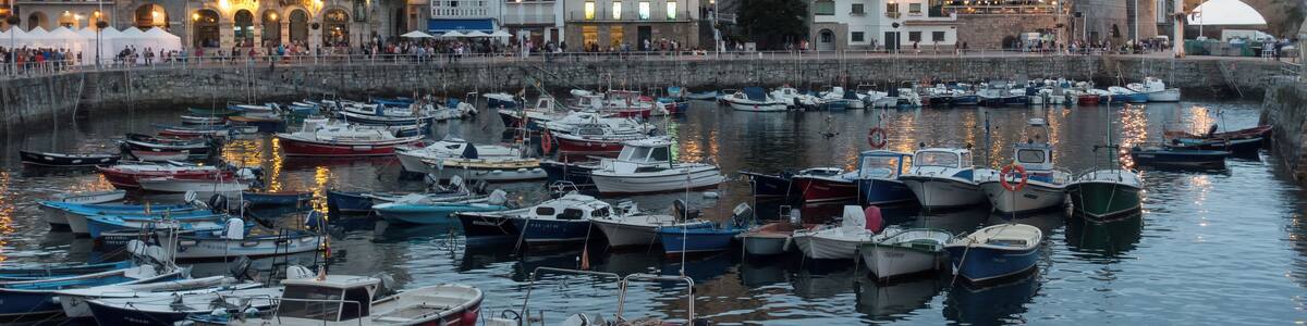 Harbour of Castro Urdiales in Cantabria, Spain. Church of Santa María de la Asunción and lighthouse in Castle of Santa Ana at the background.
