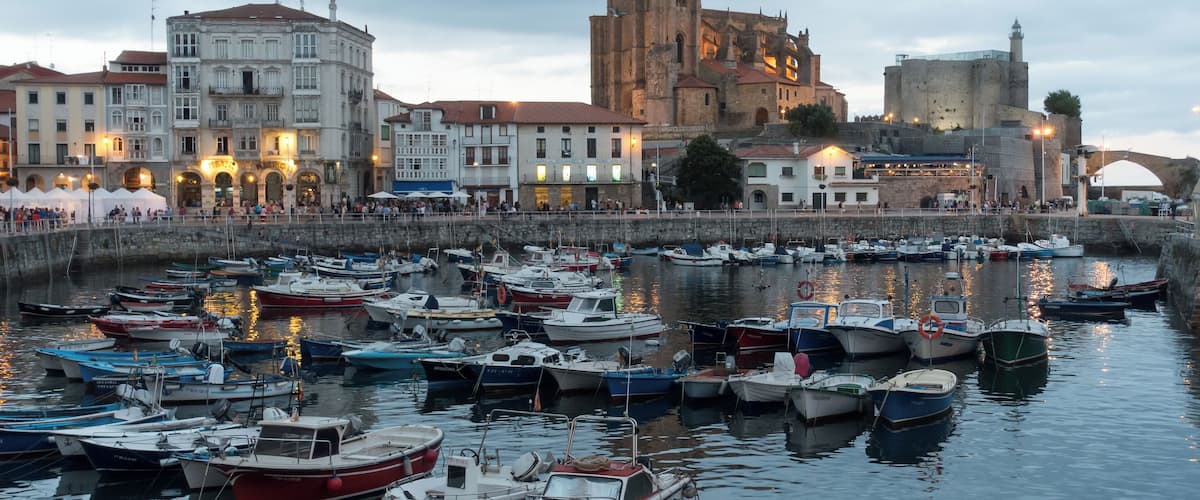 Harbour of Castro Urdiales in Cantabria, Spain. Church of Santa María de la Asunción and lighthouse in Castle of Santa Ana at the background.