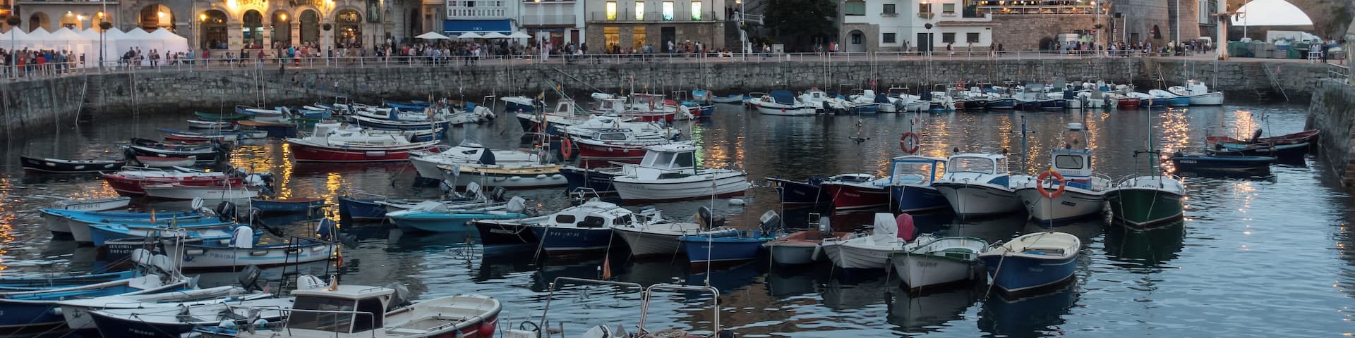 Harbour of Castro Urdiales in Cantabria, Spain. Church of Santa MarĂa de la AsunciĂłn and lighthouse in Castle of Santa Ana at the background.