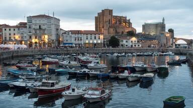 Harbour of Castro Urdiales in Cantabria, Spain. Church of Santa María de la Asunción and lighthouse in Castle of Santa Ana at the background.