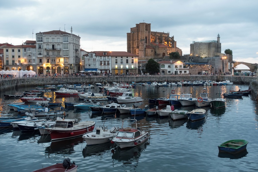 Harbour of Castro Urdiales in Cantabria, Spain. Church of Santa María de la Asunción and lighthouse in Castle of Santa Ana at the background.
