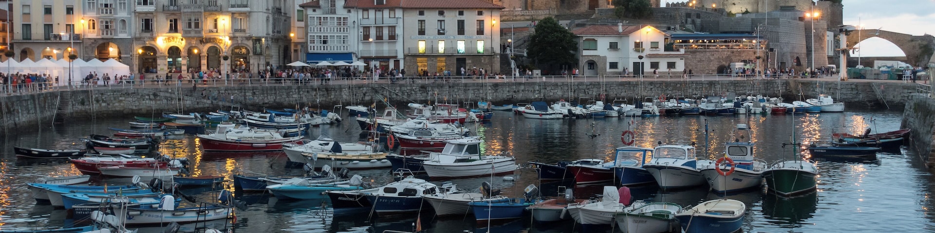 Harbour of Castro Urdiales in Cantabria, Spain. Church of Santa María de la Asunción and lighthouse in Castle of Santa Ana at the background.