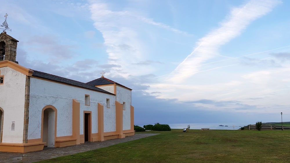 A small church with a bell tower and a clear sky.