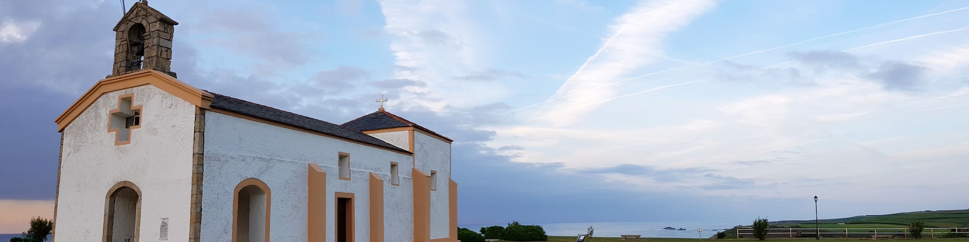 Una iglesia pequeña con un campanario y cielo despejado.