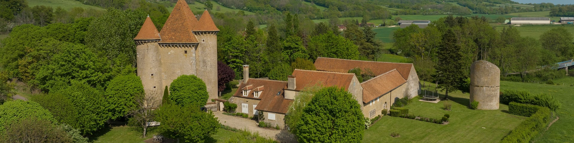 Aerial view of the Pancy castle in Angely Burgundy France with central keep protected by two circular towers, large outbuildings create a U-shaped wind around the courtyard standalone circular tower