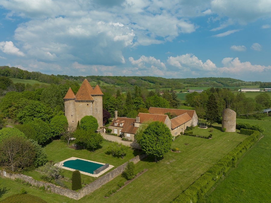 Aerial view of the Pancy castle in Angely Burgundy France with central keep protected by two circular towers, large outbuildings create a U-shaped wind around the courtyard standalone circular tower