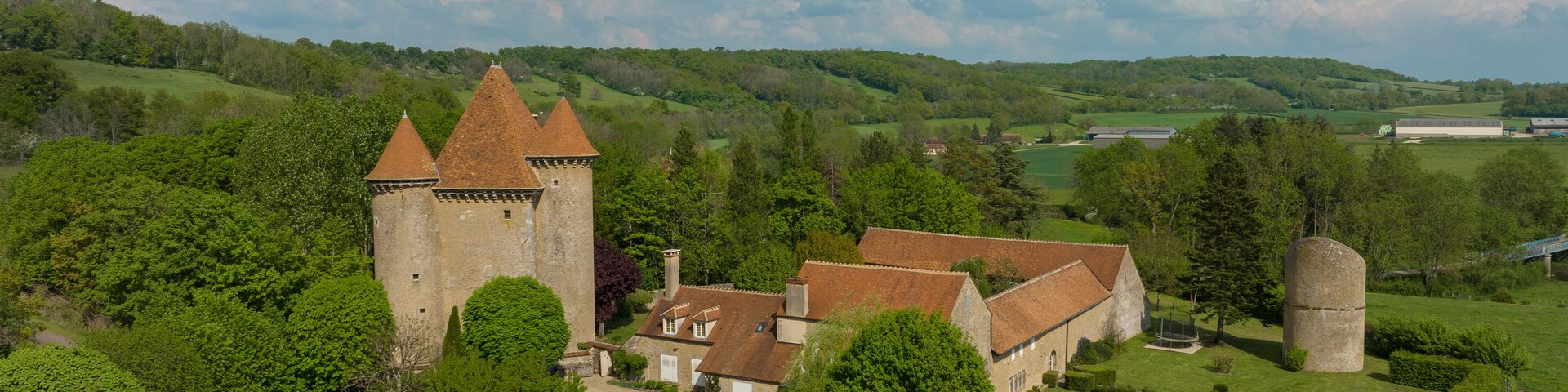 Aerial view of the Pancy castle in Angely Burgundy France with central keep protected by two circular towers, large outbuildings create a U-shaped wind around the courtyard standalone circular tower