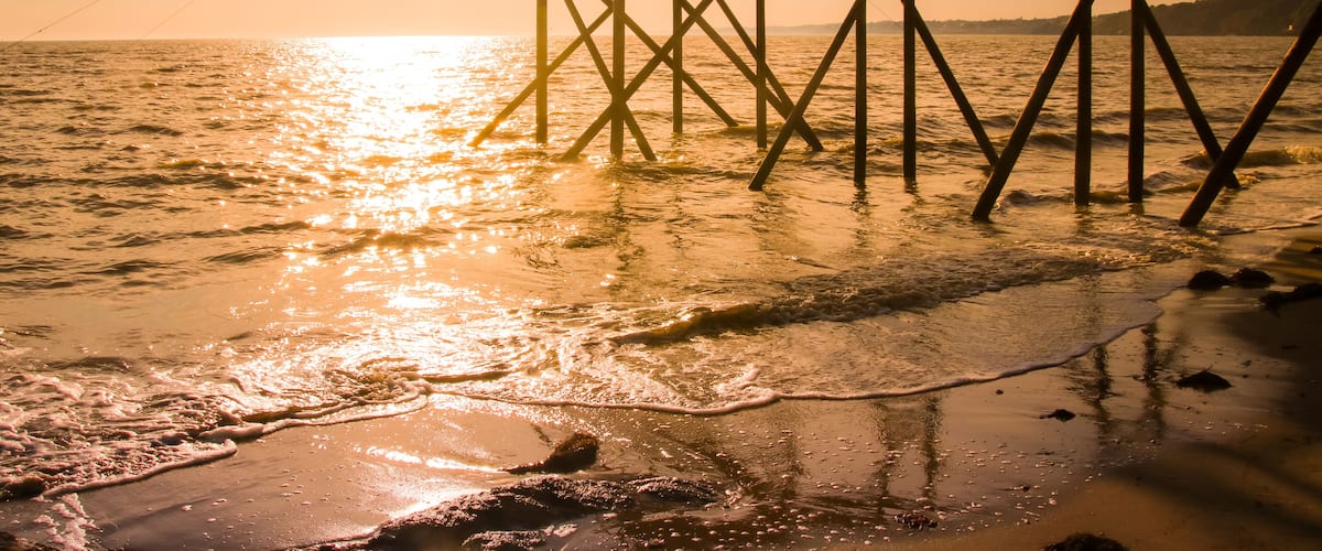 A pier extending into the water with a fishing net.