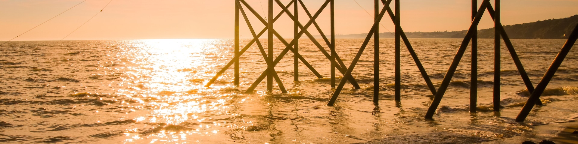 A pier extending into the water with a fishing net.