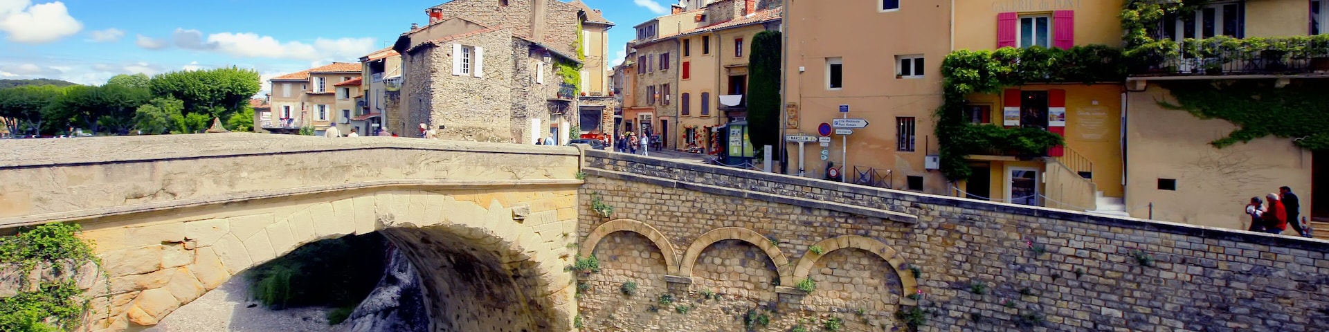 A stone bridge over a river, with buildings on either side.
