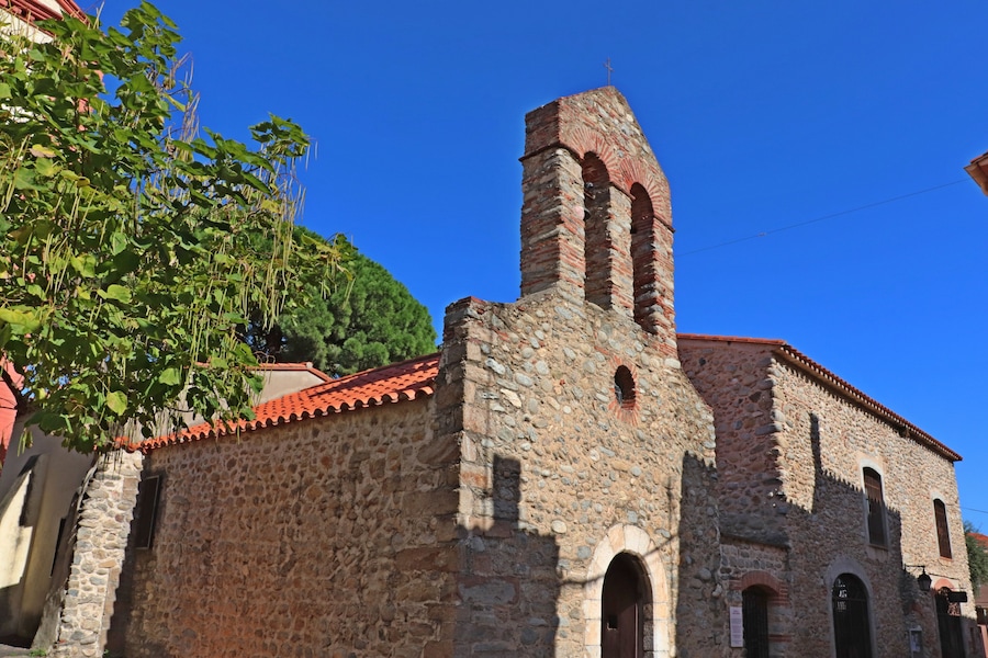 A stone church with a bell tower and arched windows.