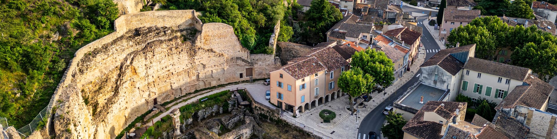 An ancient stone bridge, a town with historic buildings, and a lush green hillside.